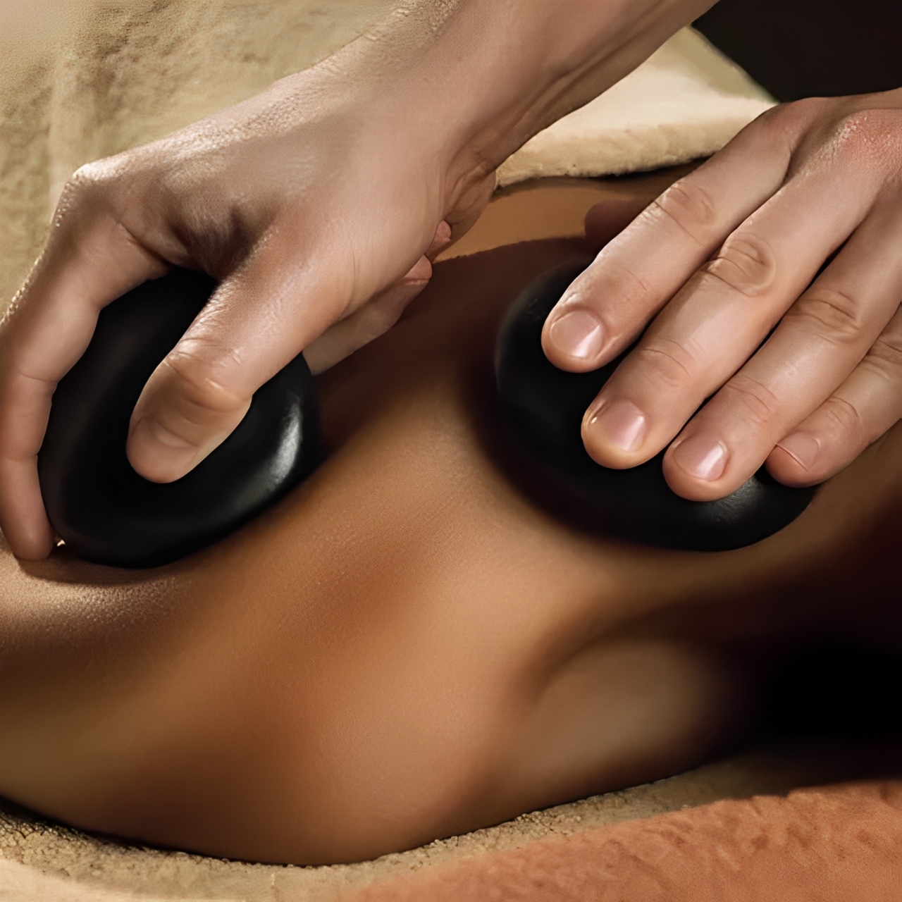 Hot stone massage at Fit Foot Massage Omaha – expert therapist using warm stones to ease deep muscle tension.