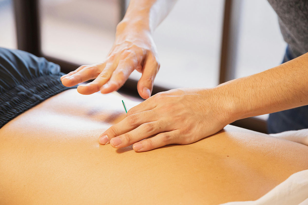 Practitioner performing Chinese massage technique on back