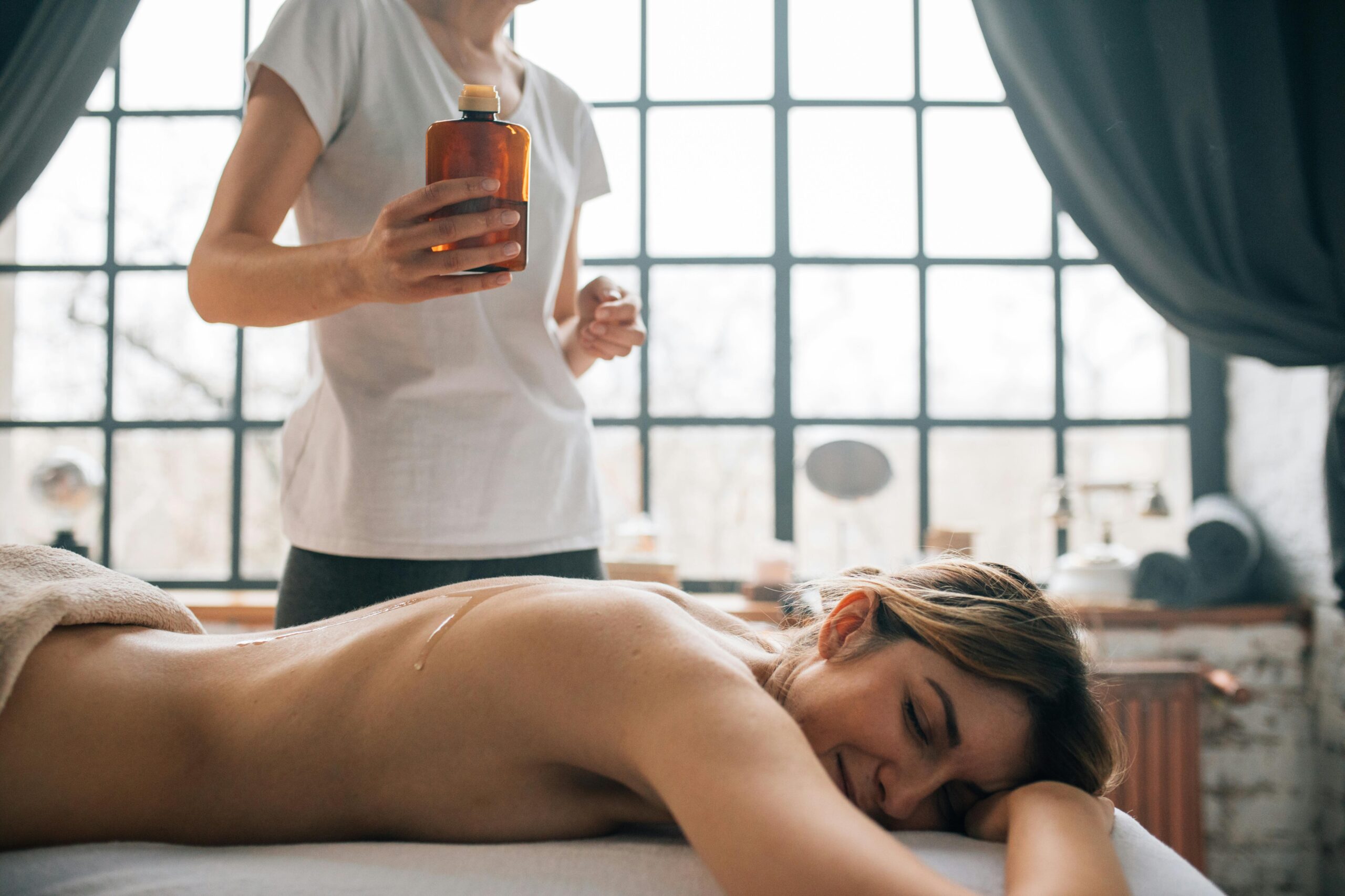 Essential Oil Massage therapist applying oil to back