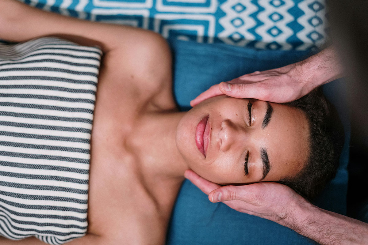 Korean massage therapist applying pressure along back muscles