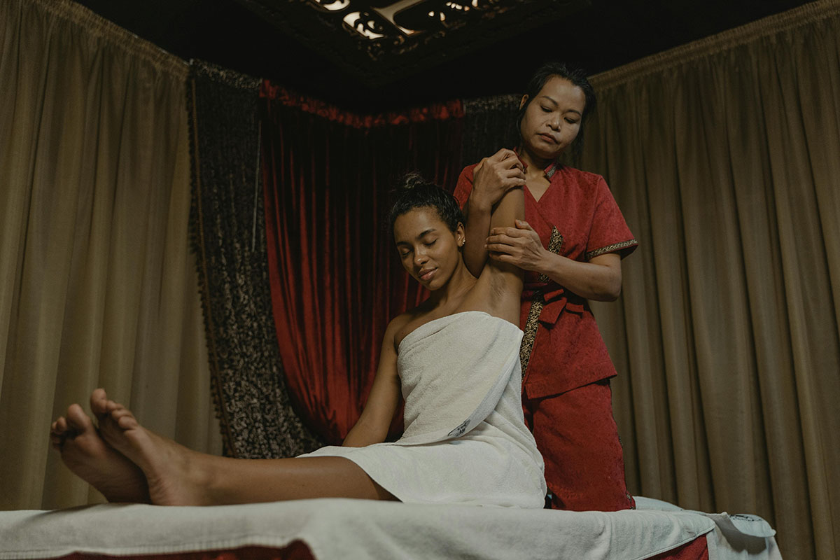 Therapist performing assisted stretch during Thai massage session